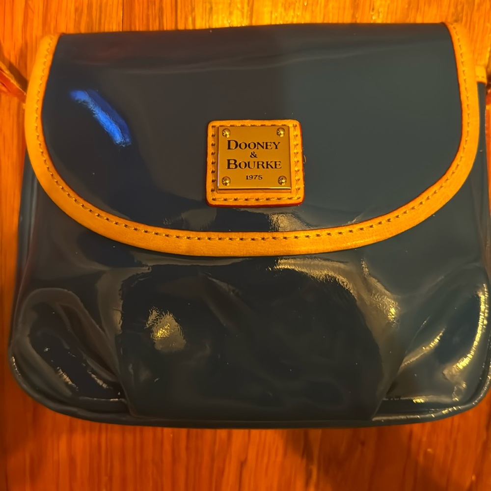 Dooney and Bourke cross body with red linning and zipper pocket.